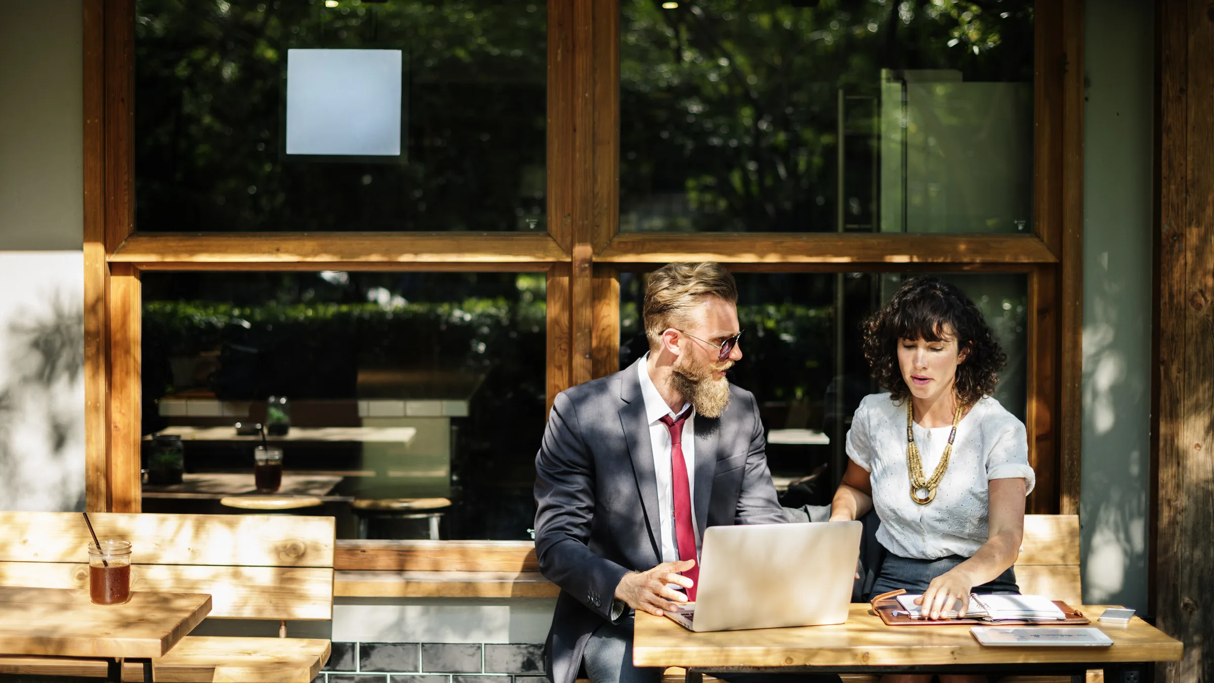 Two colleagues working through a plan together at a laptop